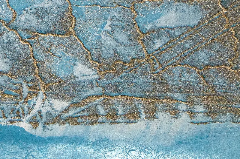 Sol craquelé de Camargue vu du ciel, bleu et or