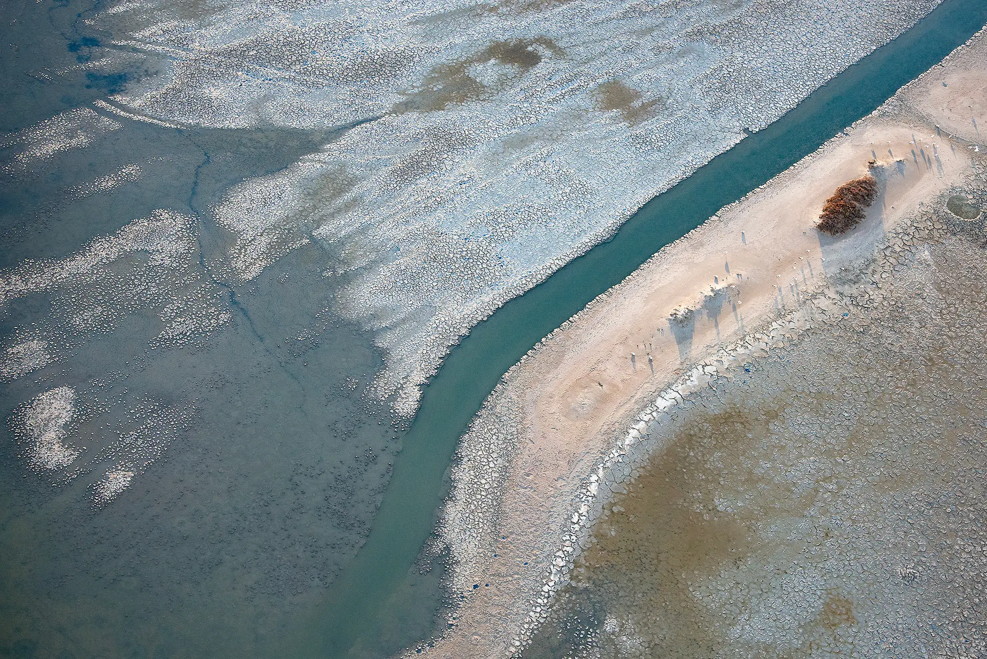 Camargue vue du ciel, un chenal d'eau verte longe une langue de sable clair